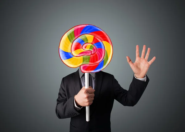 Businessman holding a lollipop — Stock Photo, Image