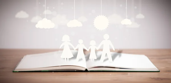 Ailenin karton figürleri açık bir kitabın üzerinde. — Stok fotoğraf