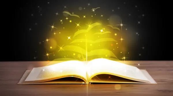 Öppen bok med gyllene glödande papper sidor — Stockfoto