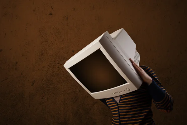 Chica con un monitor en la cabeza y copyspace marrón vacío —  Fotos de Stock