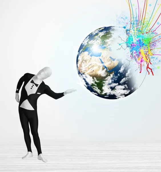 Funny man in body suit looking at colorful splatter earth — Stock Photo, Image