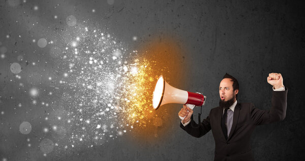 Guy shouting into megaphone and glowing energy particles explode