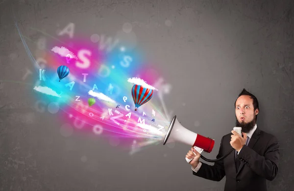 Man shouting into megaphone and abstract text and balloons come — Stock Photo, Image