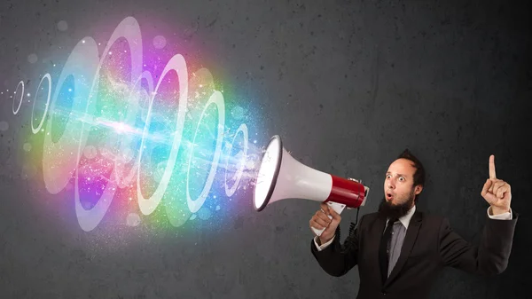 Man yells into a loudspeaker and colorful energy beam comes out — Stock Photo, Image