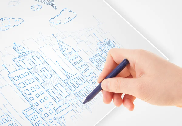 Una persona dibujando bosquejo de una ciudad con globos y nubes en un — Foto de Stock