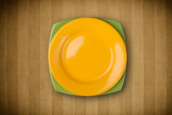 Барвиста порожня тарілка на гранжевому фоновому столі — стокове фото