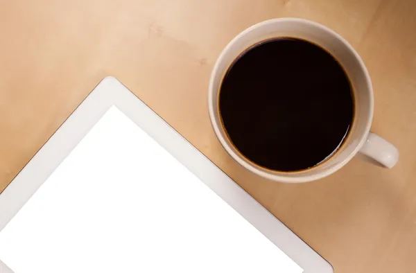 Tablet pc with empty space and a cup of coffee on a desk — Stock Photo, Image