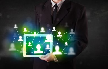 Yeşil sosyal medya simgeleriyle tablet sunan genç kişi
