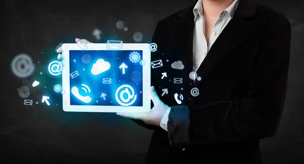 Person holding a tablet with blue technology icons and symbols — Stock Photo, Image