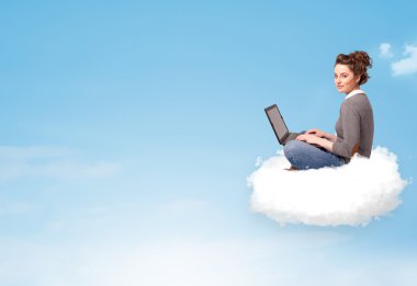 laptop kopya alanı ile bulut üzerinde oturan genç kadın