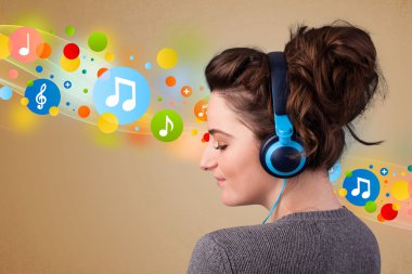 Kulaklıkla müzik dinleyen genç bir kadın. 