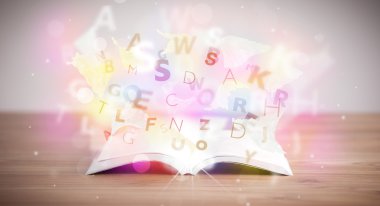 Beton zemin üzerinde parlayan harflerle kaplı kitabı aç