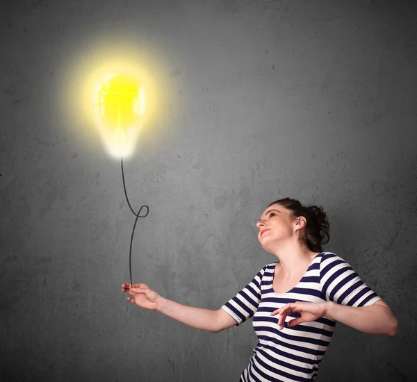 Woman holding a lightbulb balloon — Stock Photo, Image