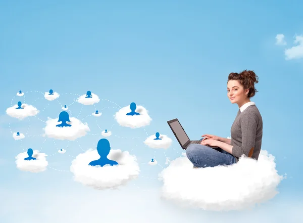 Young woman sitting in cloud with laptop — Stock Photo, Image