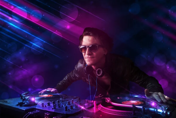 Giovane DJ che suona su giradischi con effetti di luce a colori — Foto Stock