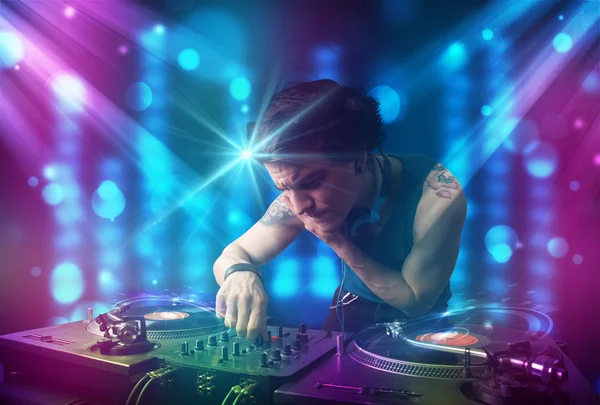 Dj mixare musica in un club con luci blu e viola — Foto Stock