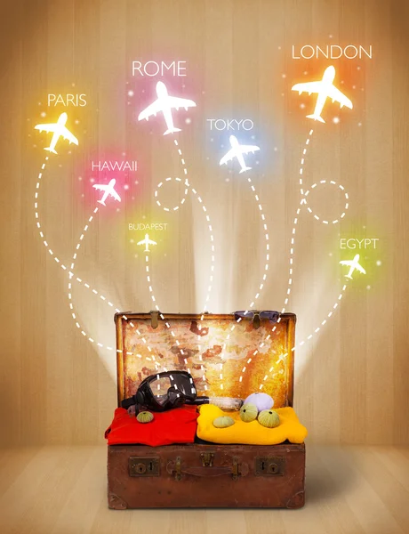 Travel bag with clothes and colorful planes flying out — Stock Photo, Image