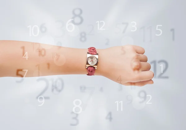 Mão com relógio e números no lado que sai — Fotografia de Stock