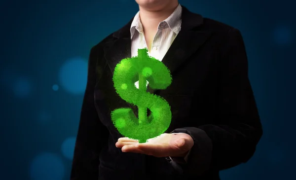 Молодая женщина представляет зеленый светящийся знак доллара — стоковое фото