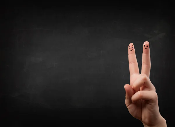 Happy smiley fingers looking at empty black chalboard — Stock Photo, Image