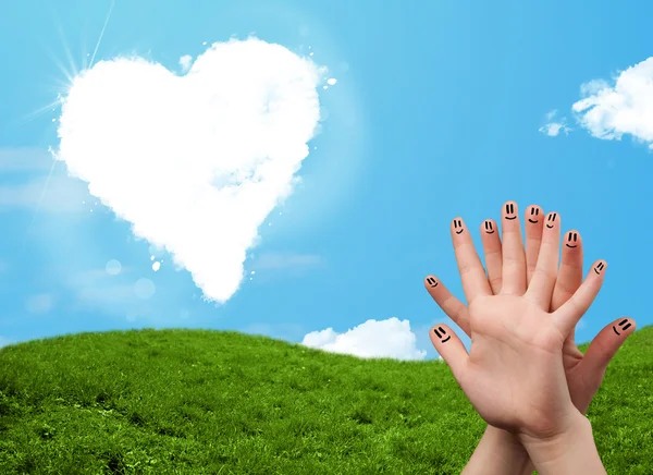 Happy smiley fingers looking at heart shaped cloud — Stock Photo, Image