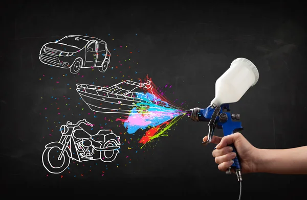 Mann mit Airbrush-Sprühfarbe mit Auto-, Boots- und Motorradzeichnung — Stockfoto