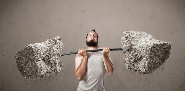 Skinny guy lifting large rock stone weights — Stock Photo, Image