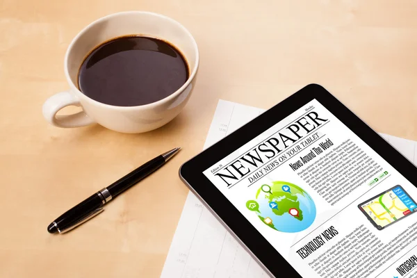 Tablet pc shows news on screen with a cup of coffee on a desk — Stock Photo, Image