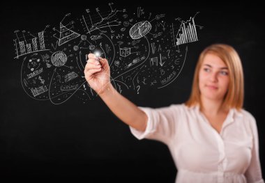 Güzel kız duvarda grafik ve diyagramlar çiziyor.