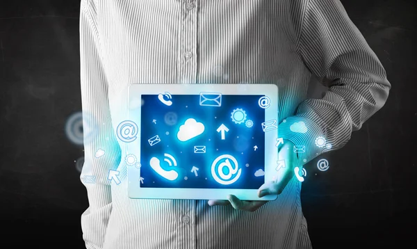 Persona sosteniendo una tableta con iconos y símbolos de tecnología azul — Foto de Stock