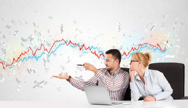 Business man and woman sitting at table with stock market graph — Stock Photo, Image