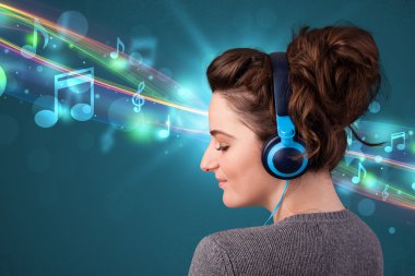 Kulaklıkla müzik dinleyen genç bir kadın.