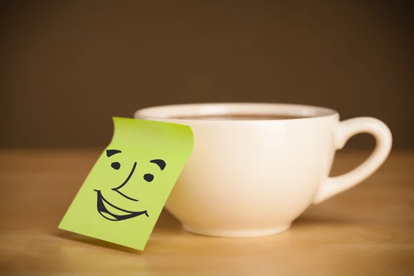 Nota post-it con la cara sonriente pegada en una taza — Foto de Stock