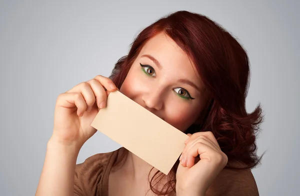 Cute girl holding white card at front of her lips with copy spac — Stock Photo, Image