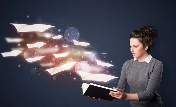 Jovencita leyendo un libro con sábanas voladoras saliendo de la b — Foto de Stock