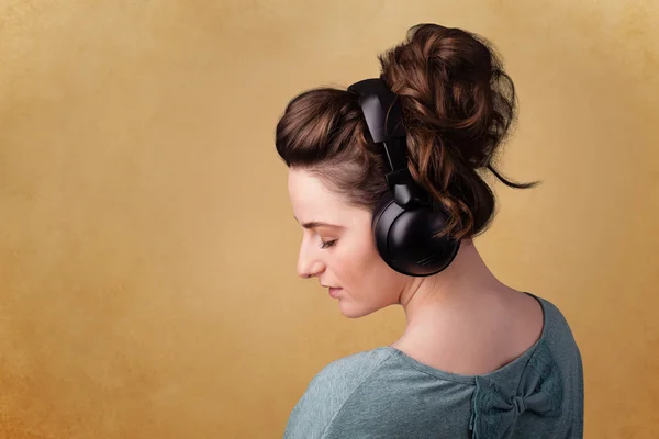 Young woman with headphones listening to music with copy space — Stock Photo, Image