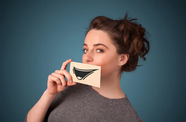 Feliz bonito menina segurando papel com engraçado smiley desenho — Fotografia de Stock