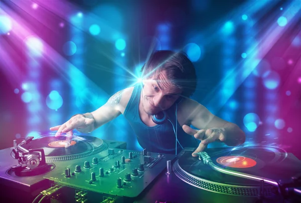 DJ blandning musik i en klubb med blå och lila ljus — Stockfoto
