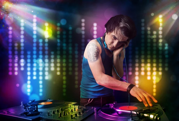 Dj tocando canciones en una discoteca con espectáculo de luz — Foto de Stock