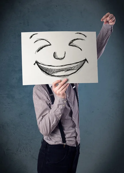 Empresário segurando um papel com rosto sorridente na frente de sua hea — Fotografia de Stock