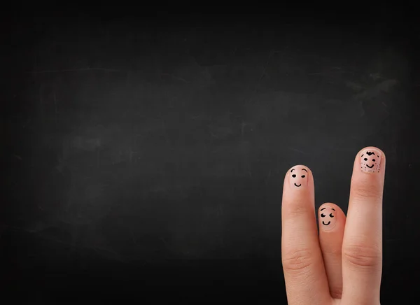 Happy smiley fingers looking at empty black chalboard — Stock Photo, Image
