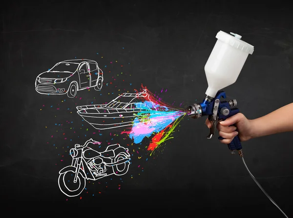 Człowiek z farby w sprayu airbrush z samochodu, łodzi i motocykl narysować — Zdjęcie stockowe