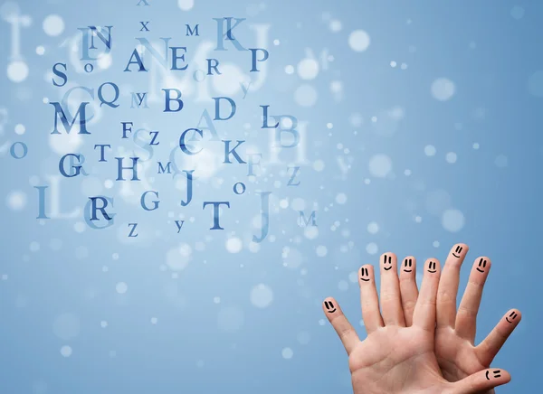 Happy smiley fingers looking at mixture of bokeh letters — Stock Photo, Image