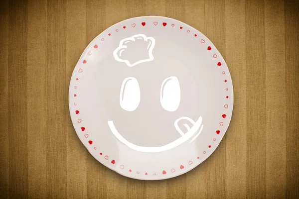 Renkli tabak üzerinde mutlu bir çizgi film yüzü — Stok fotoğraf