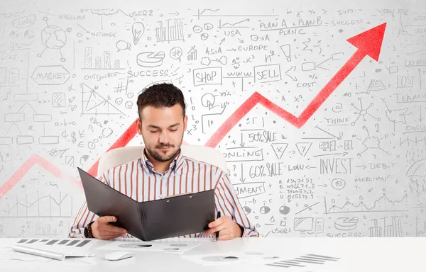 Business man sitting at table with market diagrams — Stock Photo, Image