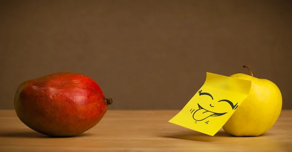 Apple met post-it note uitsteekt tong aan mango — Stockfoto