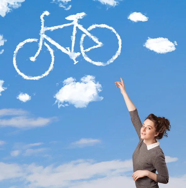 年轻的女孩低头看自行车在蓝蓝的天空上的云 — 图库照片