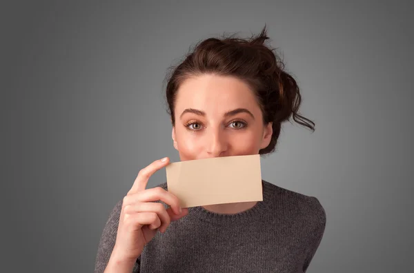 Menina bonito segurando cartão branco na frente de seus lábios com cópia spac — Fotografia de Stock