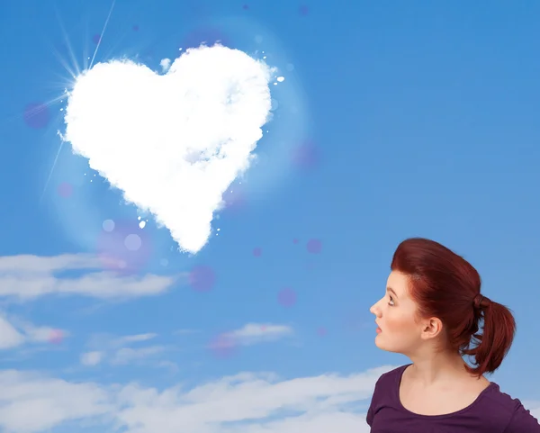 Linda chica mirando a la nube blanca del corazón en el cielo azul —  Fotos de Stock