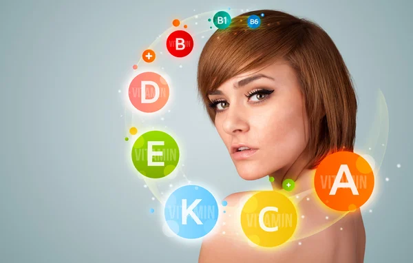 Menina bonita com ícones de vitaminas coloridas e símbolos — Fotografia de Stock